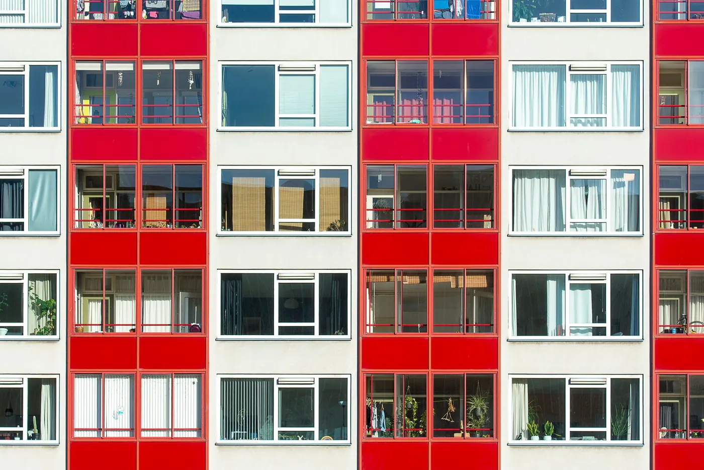 A block of flats with red and white balconies