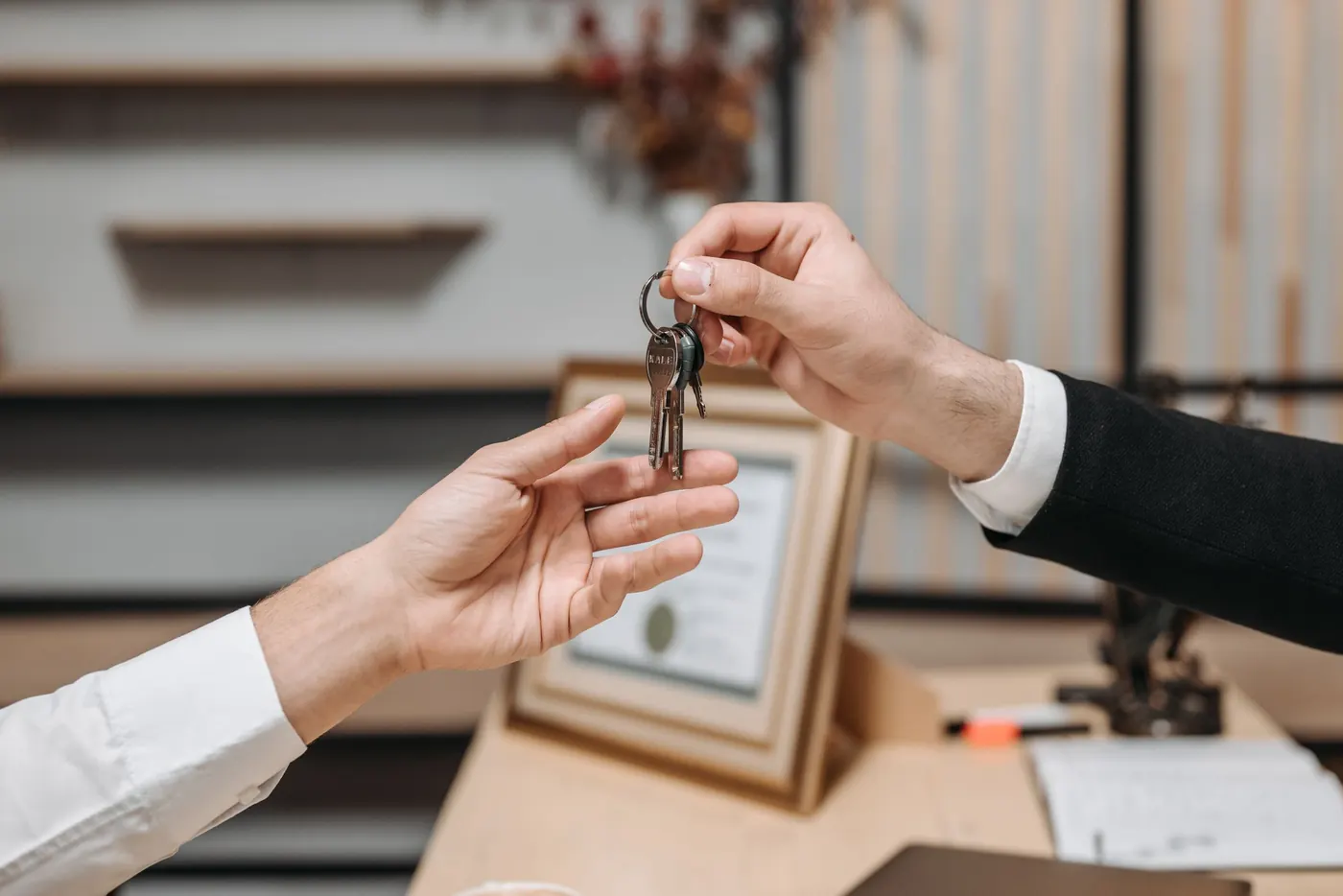A set of keys being handed across a desk