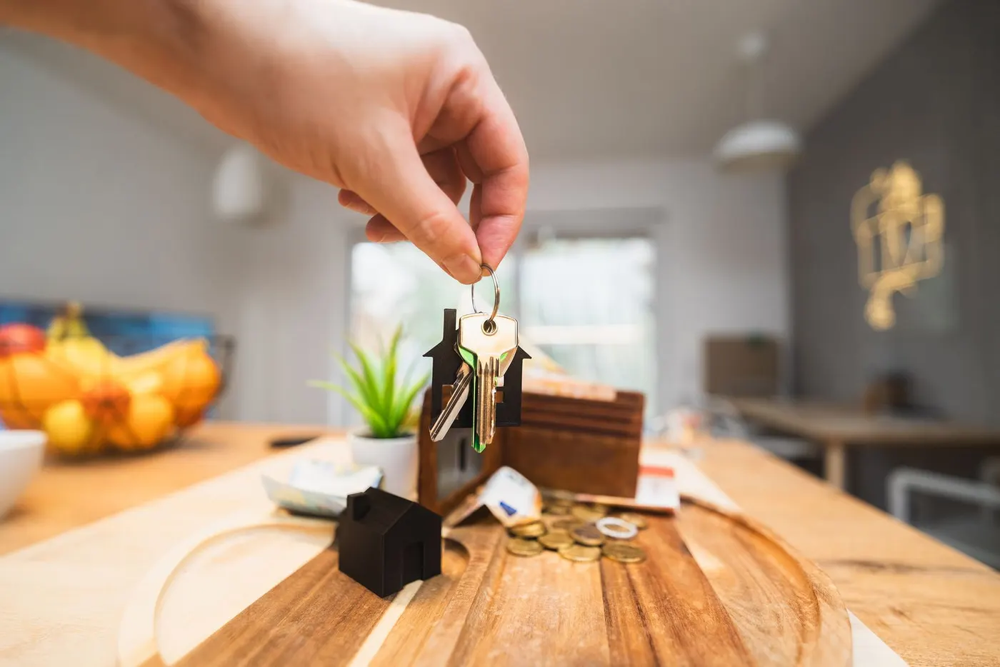 Keys with a house keyring held over a kitchen table