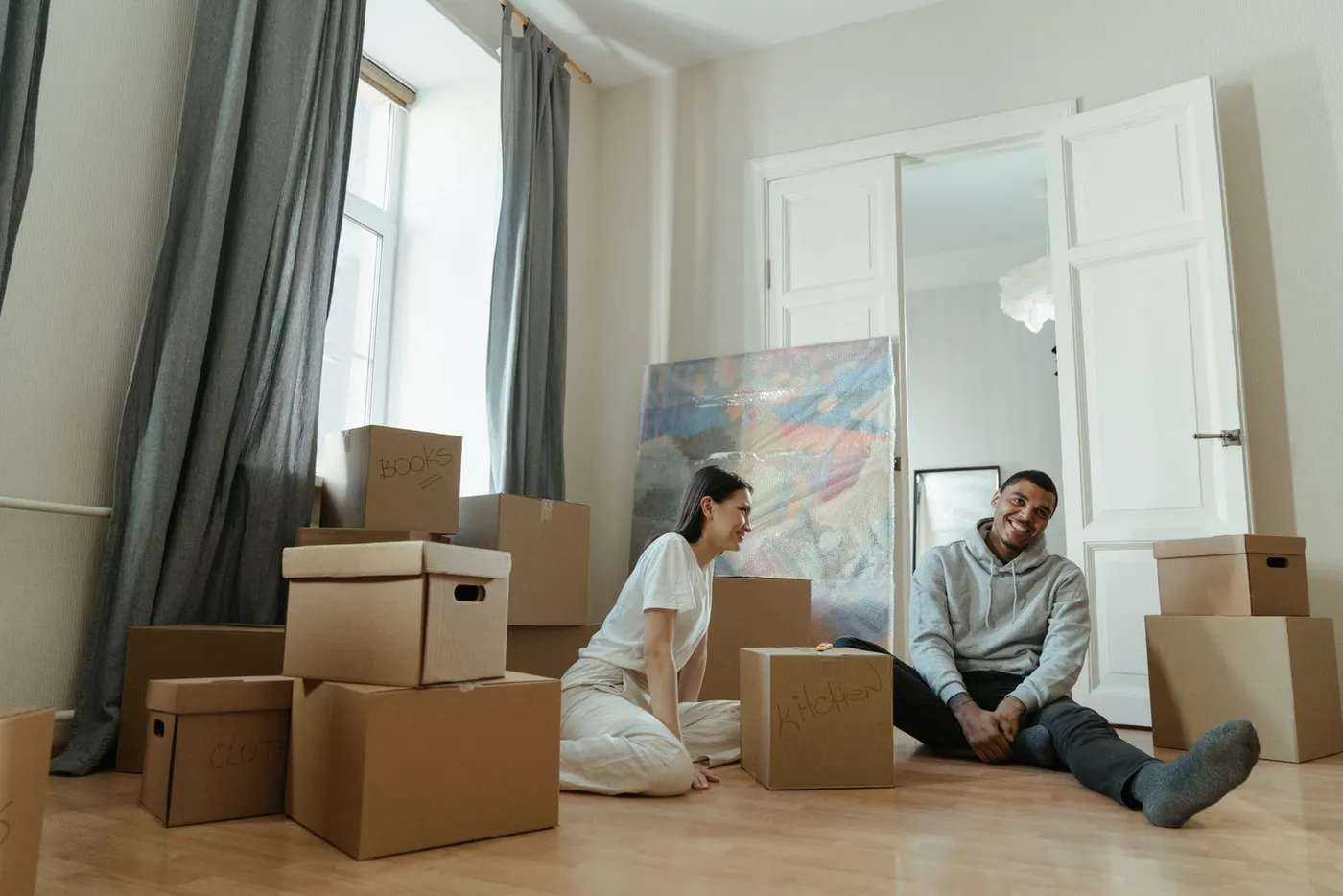 Tenants sitting among boxes on moving-in day